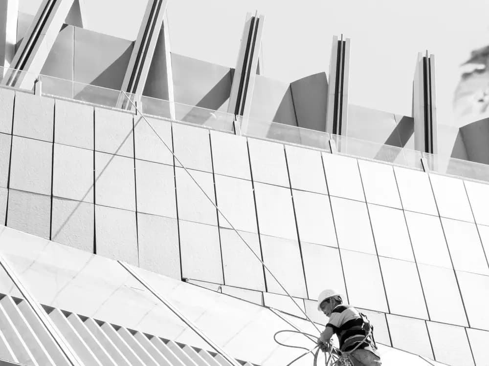 Técnico trabajando sobre la cubierta de un edificio con equipo de seguridad